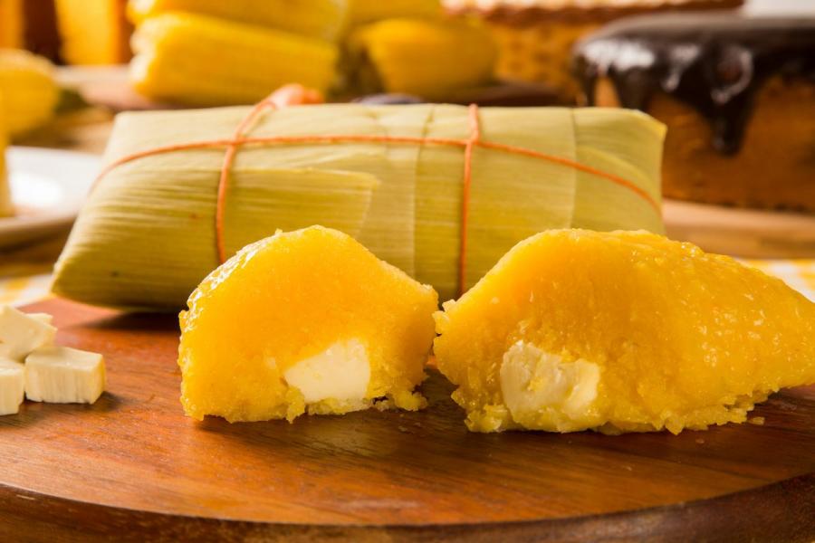 Pamonha de queijo, una pasta elaborada con maíz fresco y queso, que se envuelve en hojas de maíz y se cocina.