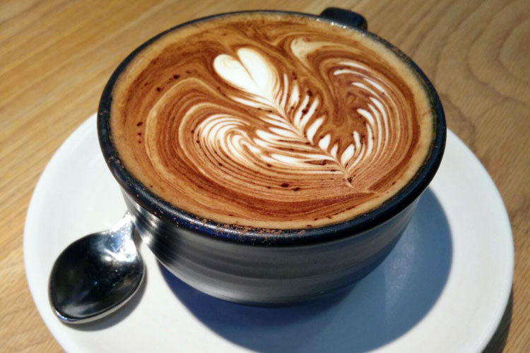 Taza de café con decoración en la espuma.