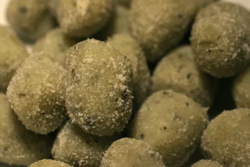 Detalle de ñoquis de patata con puré de espinacas.