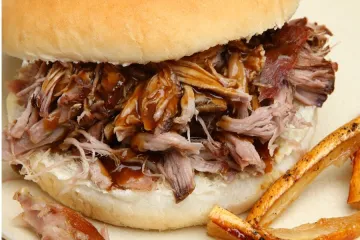 Bocadillo de carne de cerdo asada con salsa barbacoa.