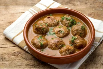 Una cazuelita de barro con albóndigas en salsa.