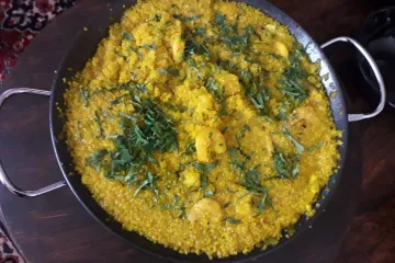 Quinotto con camarones adornado con cilantro.
