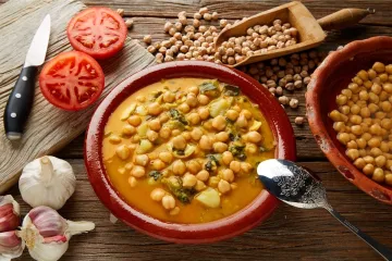 Una cazuela de barro con potaje de garbanzos y espinacas.