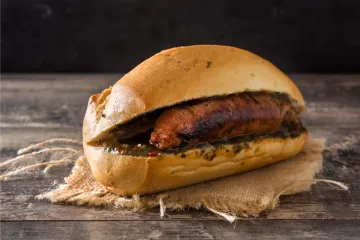 Choripan, un bocadillo de chorizo frito, o asado, servido con chimichurri.