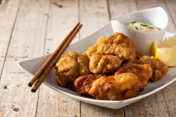 Chicken karaage japonés acompañado de limón y mayonesa.