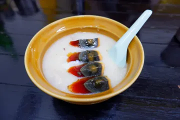 Un cuenco de arroz congee con huevos centenarios.