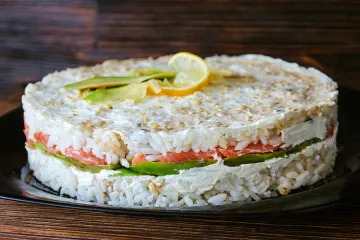 Timbal de arroz, o pastel de sushi, con aguacate, queso cremoso y salmón ahumado
