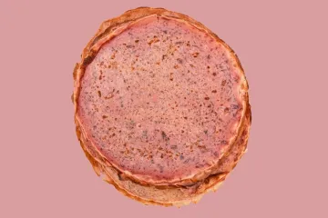 Tortitas rosadas estilo crêpe francés con trocitos de fruta y chocolate rallado.