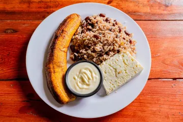Gallo pinto, arroz con alubias negras, con queso y plátano frito.