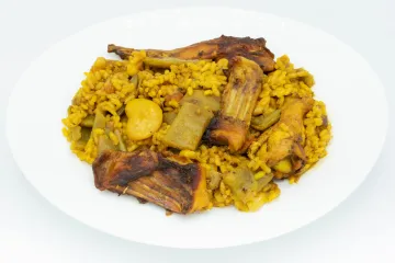 Un plato de paella valenciana tradicional con garrofón.