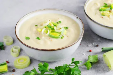 Un cuenco de potage parmentier decorado con tiras de piuerro.