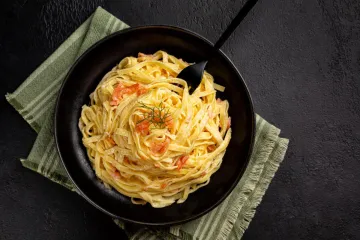 Un plato de pasta con salmón ahumado.