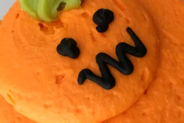 Biacochito de vainilla decorado como calabaza terrorífica.