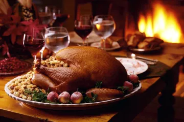 Pavo asado con sus guarniciones en una fuente de servir, ambiente festivo.