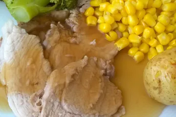 Carne de cerdo asada con su salsa de asado.