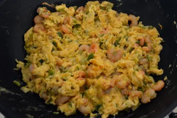 Huevos revueltos con ajetes y gambas.