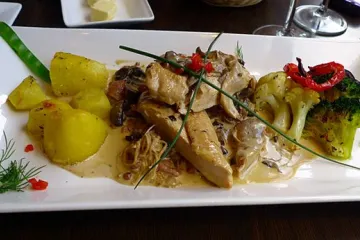 Suprema de pollo con salsa y acompañamiento.