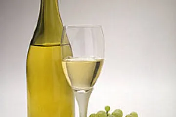 Uvas blancas, botella y copa de vino blanco.