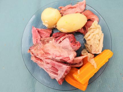 Un plato de cocido alemán con carne de cerdo, patatas, repollo y zanahoria.