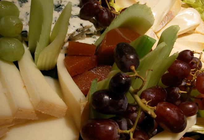 Detalle de una tabla de quesos con fruta.