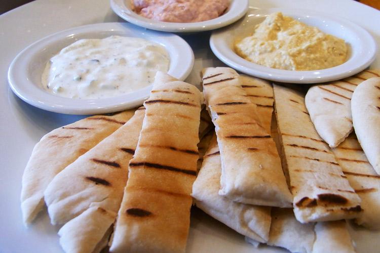 Pan pita tostado con tzatziki, taramasalata y humus.