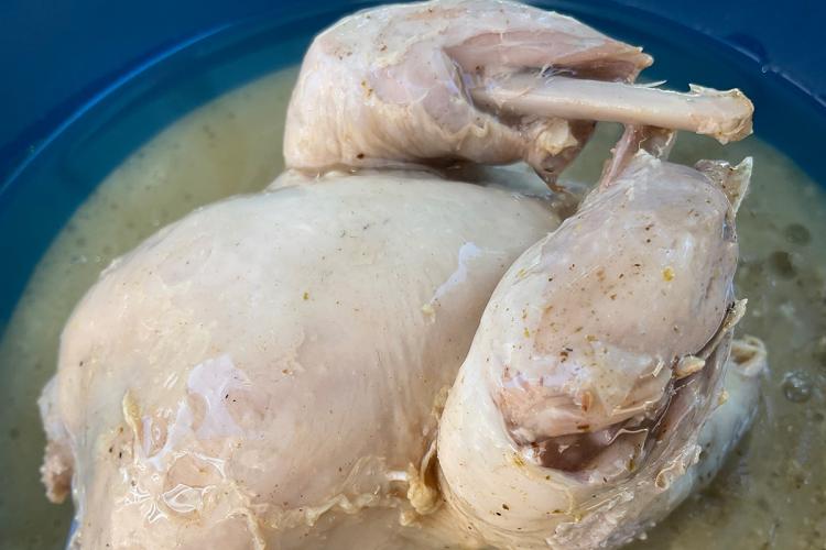 Una perdiz en escabeche en una fuente de servir de loza de color azul.