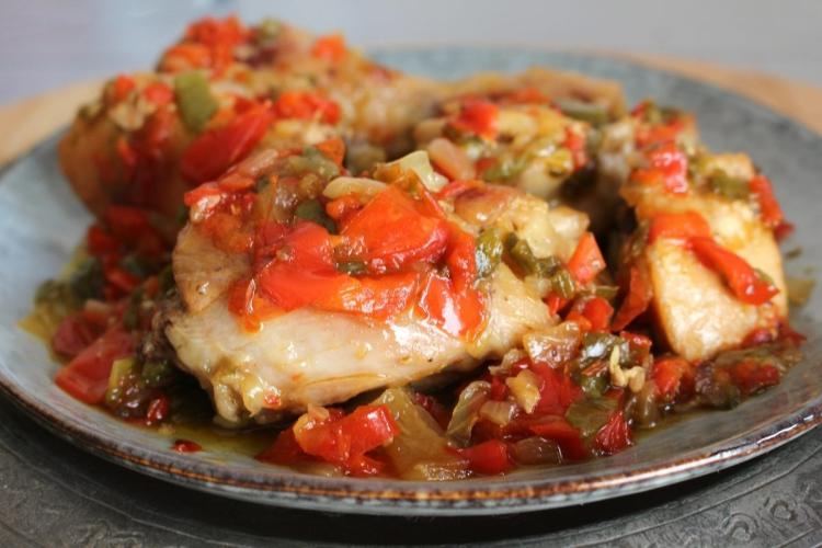 Un plato con pollo al chilindrón.