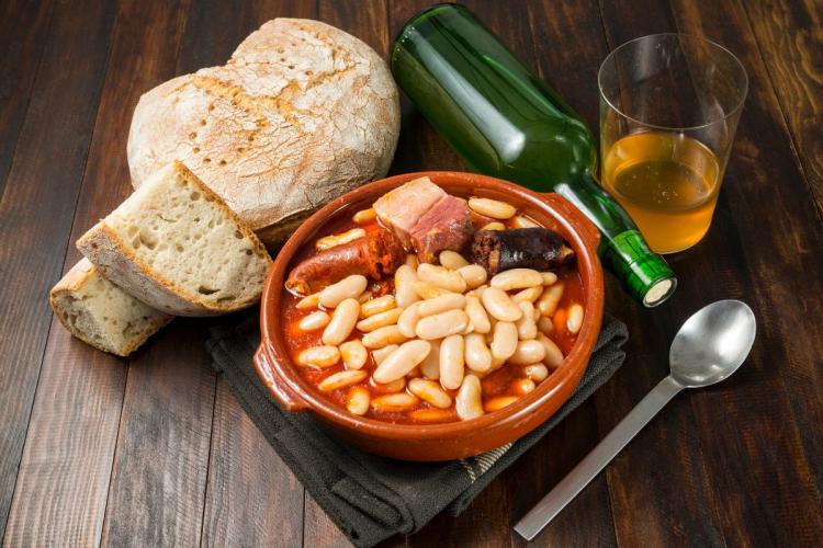 Una porción de fabada asturiana en cazuelita de barro.