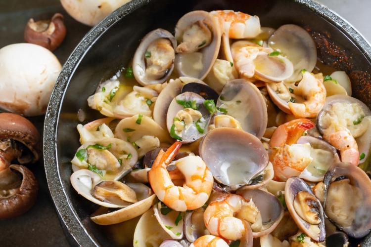 Sartenada de champiñones, almejas y langostinos, generada por IA.