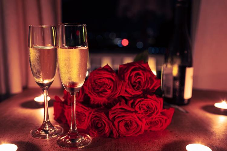 Copas de cava rosado acompañadas con rosas rojas como nota romántica.