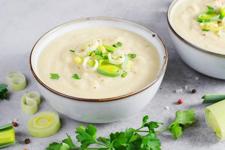 Un cuenco de potage parmentier decorado con tiras de piuerro.