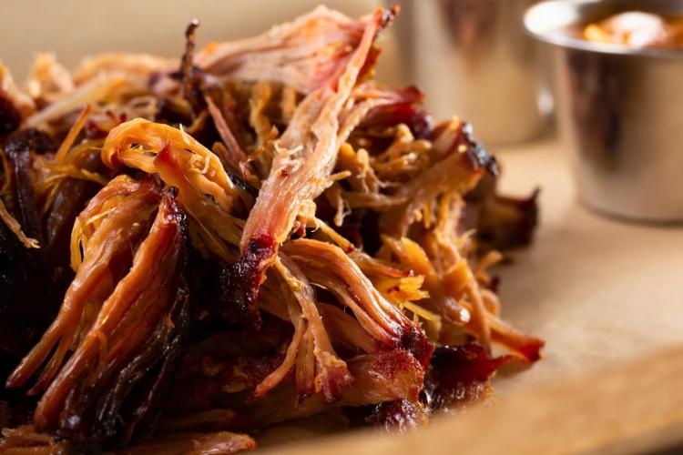 Detalle de cerdo desmenuzado servido con salsa.