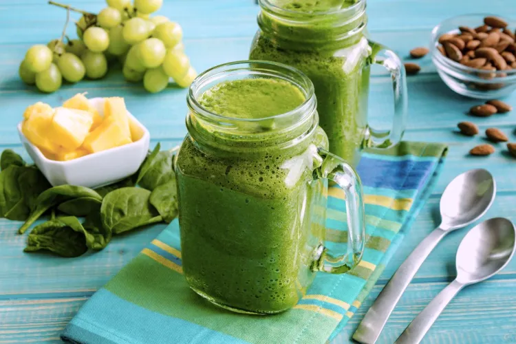 Dos tarros con batido de piña y espinacas.