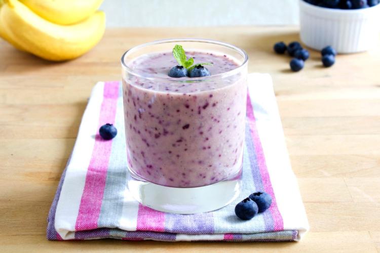 Un vaso de batido de plátano y arándanos.