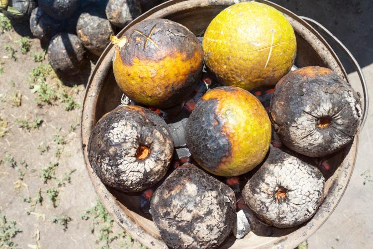 Un recipiente con varios frutos del pan asados.