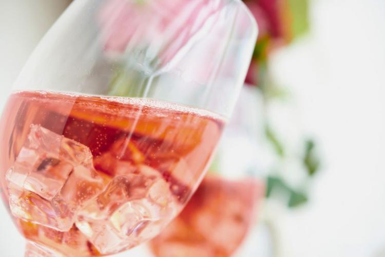 Dos copas con vino rosado espumoso servido con hielo.