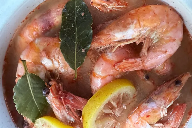 Gambas cocidas en cerveza con limón, laurel y pimienta, todavía en su líquido.