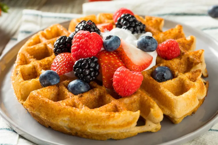 Gofre acompañado con frutos del bosque y nata.