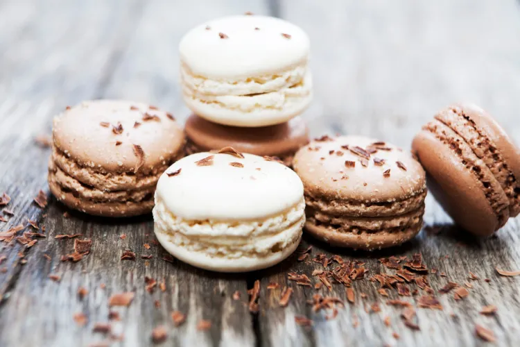 Cinco macarons sencillos, tres con sabor a chocolate y dos de vainilla.