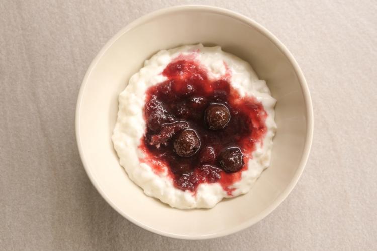 Un cuenco de risalamande con su salsa de cerezas.