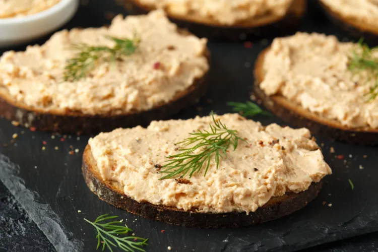 Pan tostado con paté de salmón ahumado, decorado con eneldo fresco.