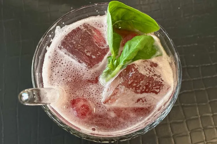 Vista superior de un vaso con limonada de frambuesa e hibisco al estilo alemán.