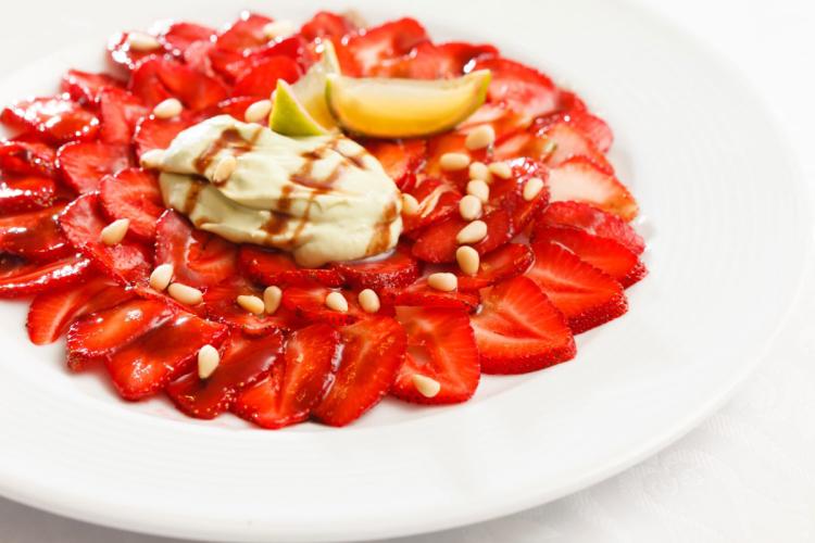 Un plato de carpaccio de fresas con ricotta, piñones y zumo de limón.