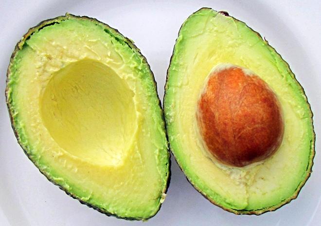 Un aguacate cortado por la mitad.