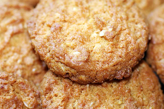 Primer plano de varias galletas ANZAC doradas y apiladas.