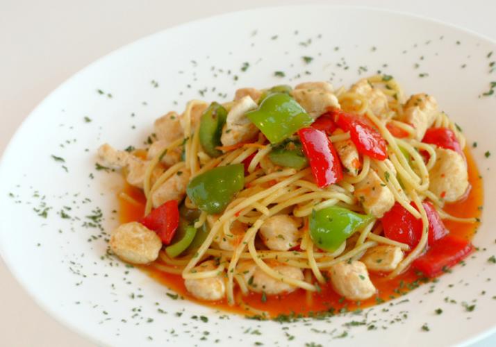 Un plato de pasta con almejas, pimientos y albahaca.