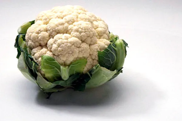Una coliflor fresca sobre fondo blanco.