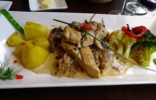 Suprema de pollo con salsa y acompañamiento.