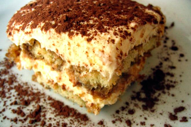 Un trozo de tiramisu decorado con cacao en polvo.
