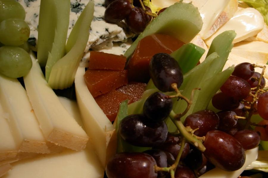 Detalle de una tabla de quesos con fruta.